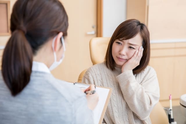 歯医者で問診を受ける女性